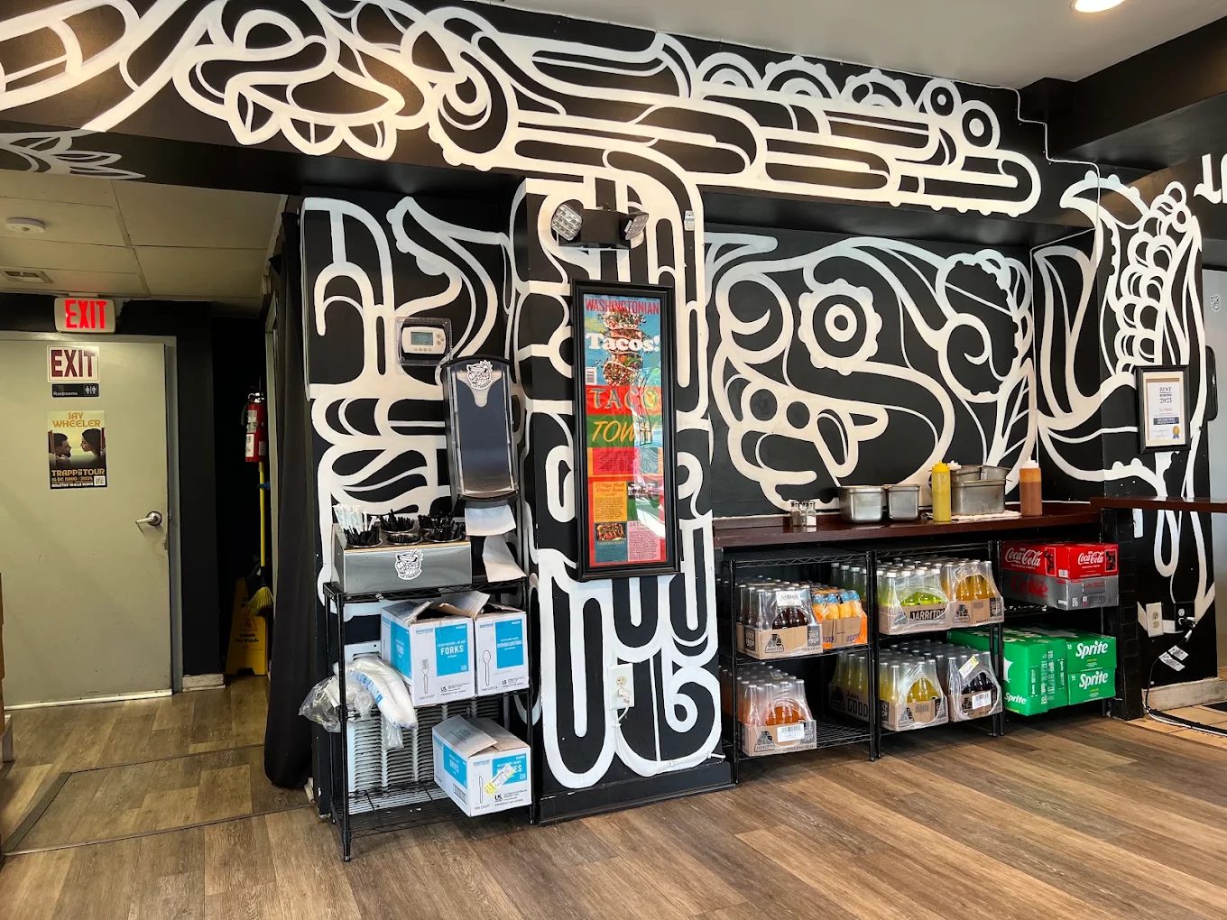 La Tingeria's Falls Church counter with drink cooler, condiments, and a framed 'Washingtonian Tacos! Taco Town' feature on the wall