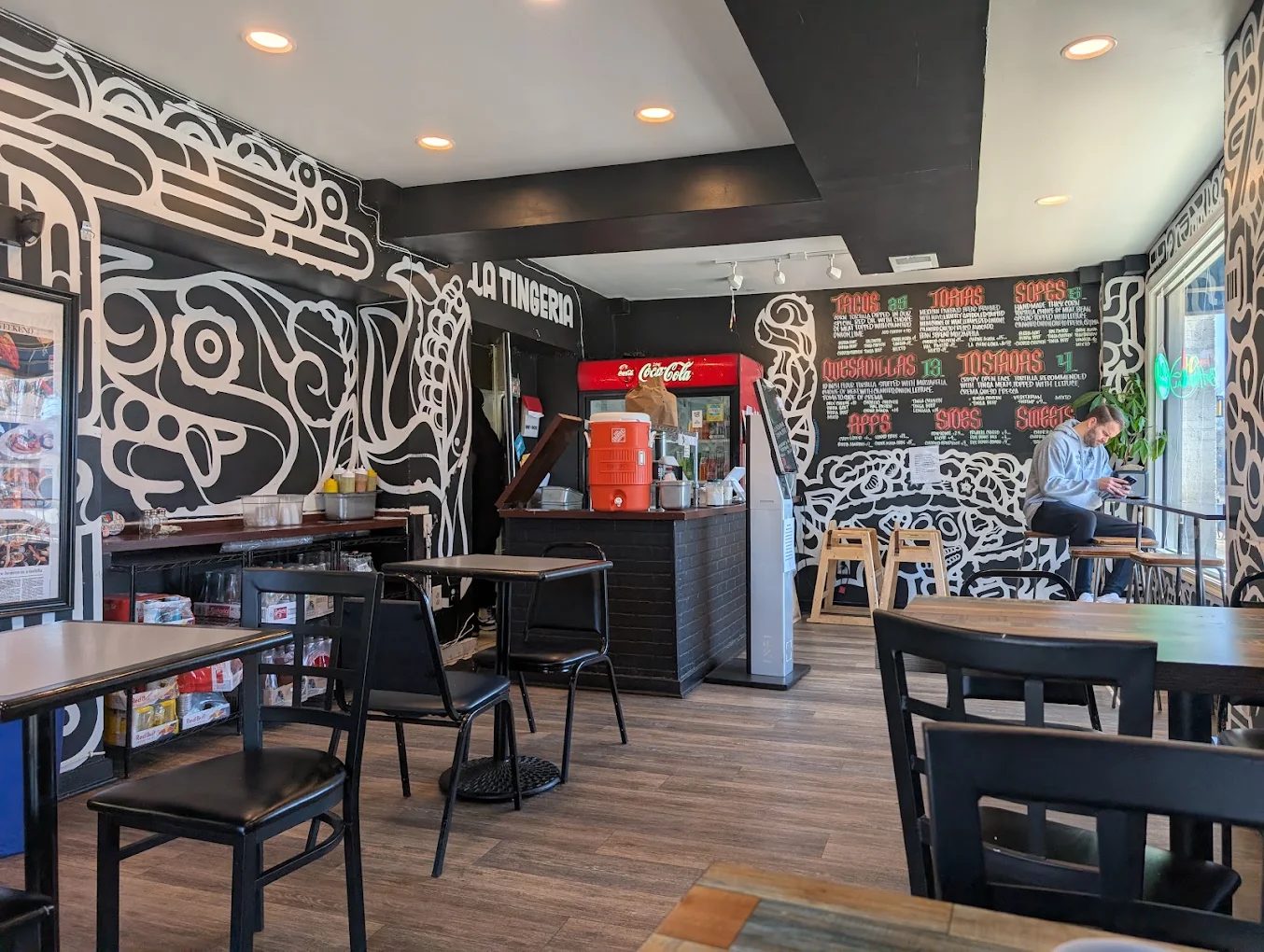 Colorful hand-painted Aztec-inspired mural and 'LA TINGERIA' wall lettering inside the Falls Church dining room