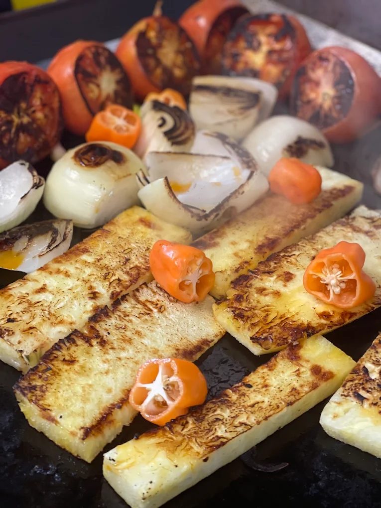 Charred tomatoes, onions, and habanero peppers on the plancha at La Tingeria, prepped for house-made salsa